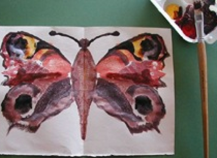 Mal en sommerfugl ved at folde våd farve.